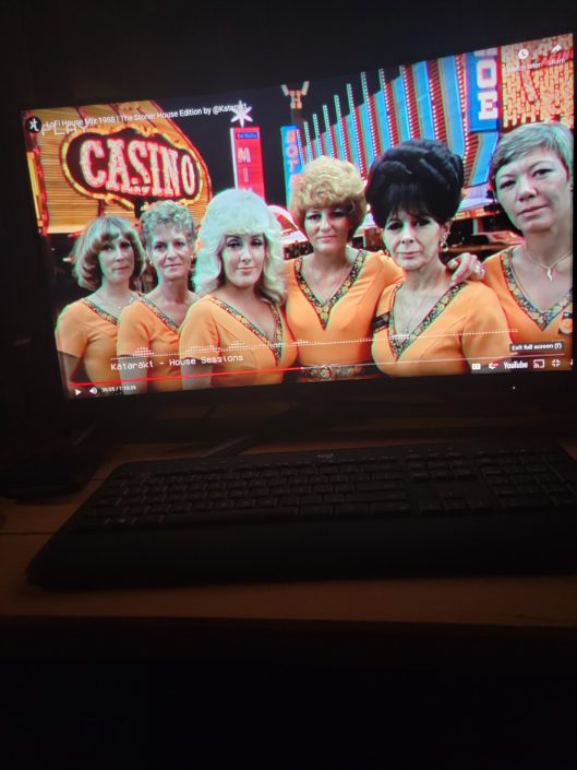 A computer screen with the image of several women in orange.