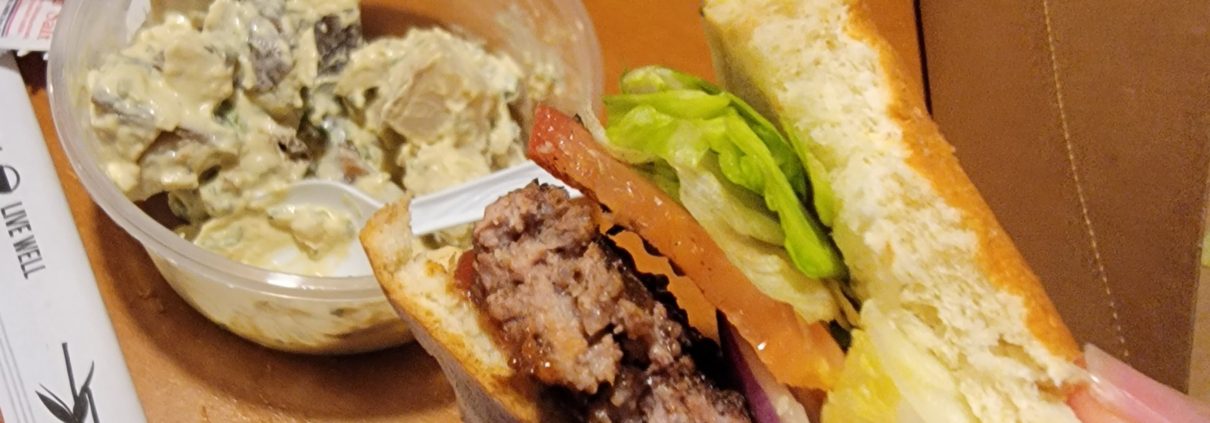 A sandwich and salad on the table at a restaurant.