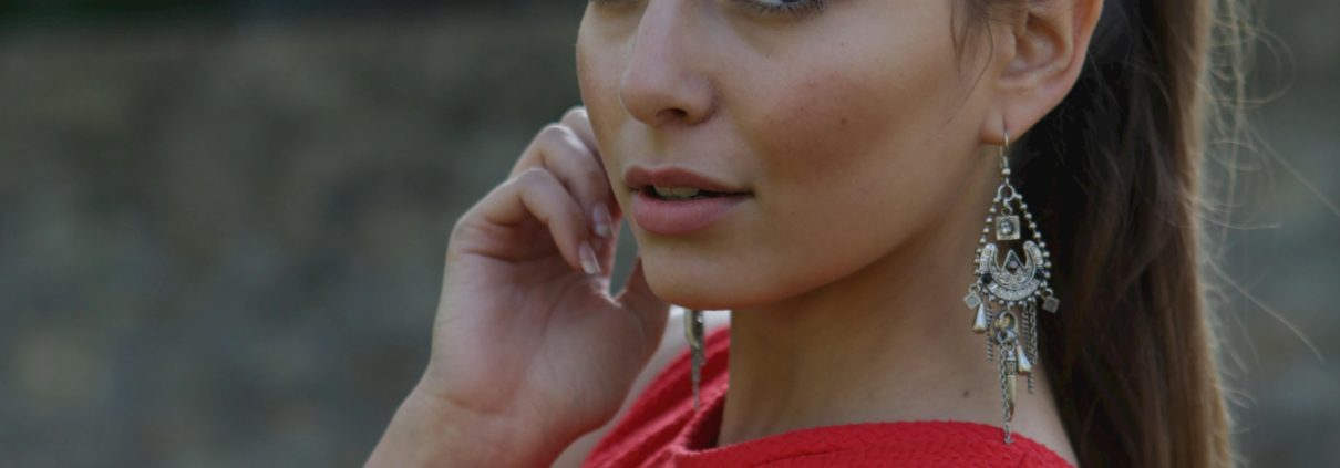 A woman in red dress talking on her cell phone.