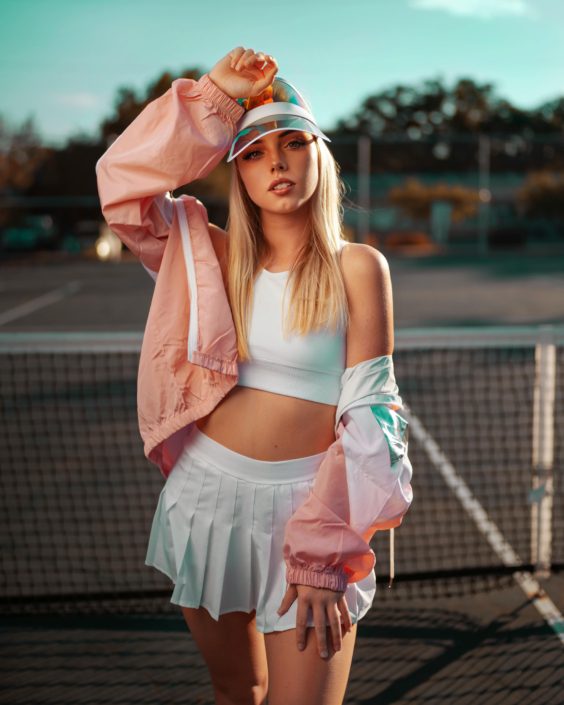 A woman in white skirt and pink jacket.