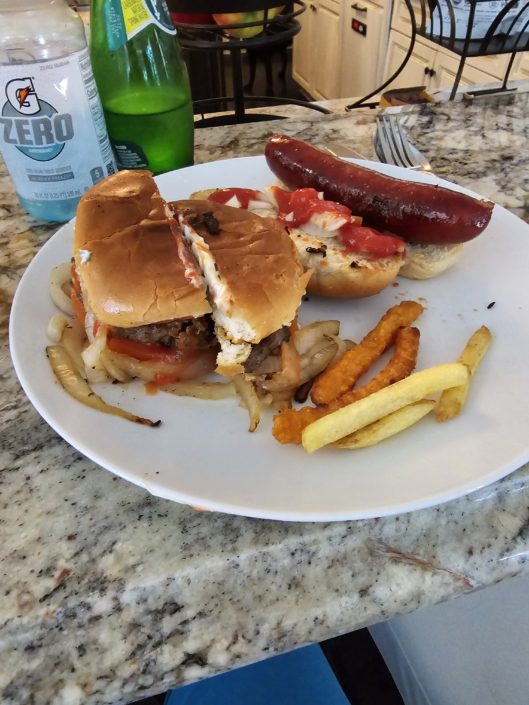 A plate of food with fries and hot dog on it.